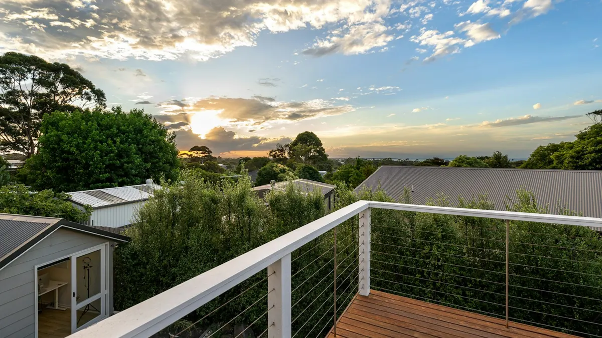 Deck corner with cable railing overlooking trees