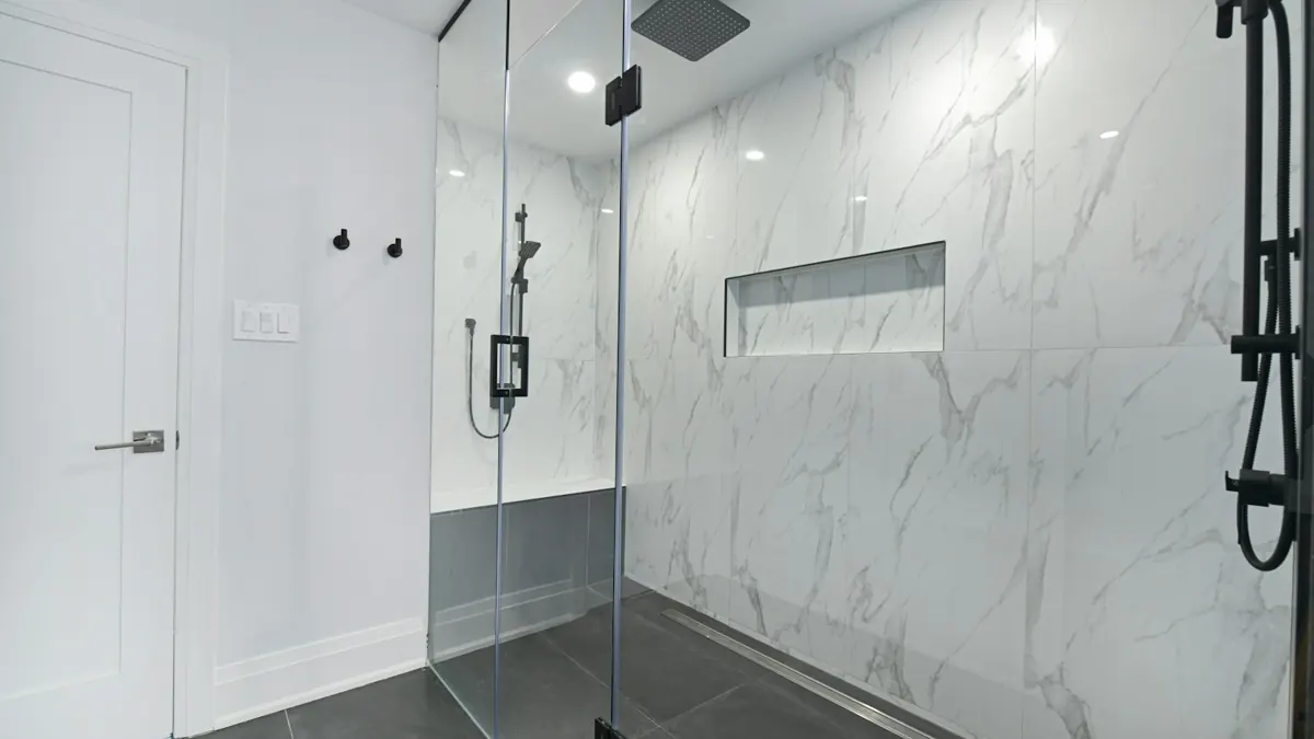 Bathroom with glass-enclosed shower and marble walls