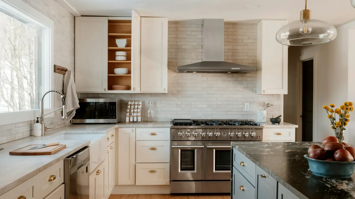 Kitchen with cream cabinets, range hood and tile backsplash