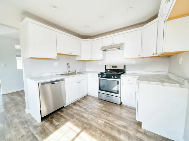 Bright remodeled kitchen with white cabinets and stainless appliances